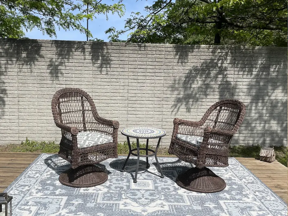 Comfortable outdoor chairs are pictured underneath calming shade during a sunny day