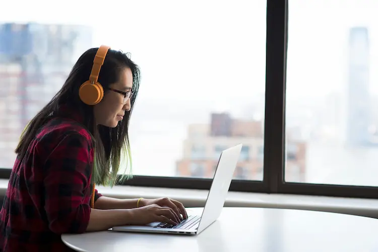 A woman enjoying a virtual therapy session on her laptop remotely